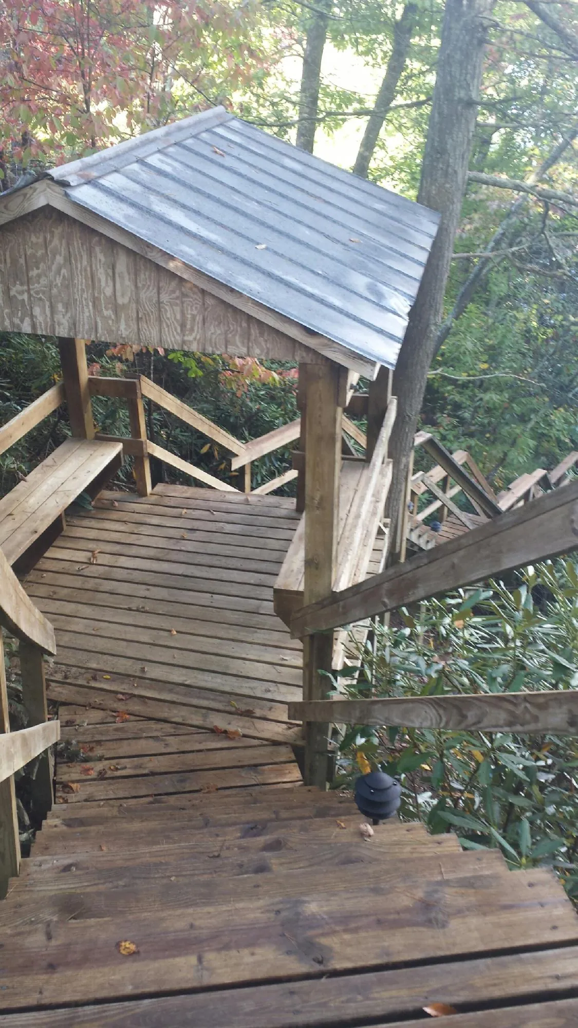Metal roofed shelter over wooden steps on a wooded walkway — Skylight Repair & Installation work by our crew in Huntsville
