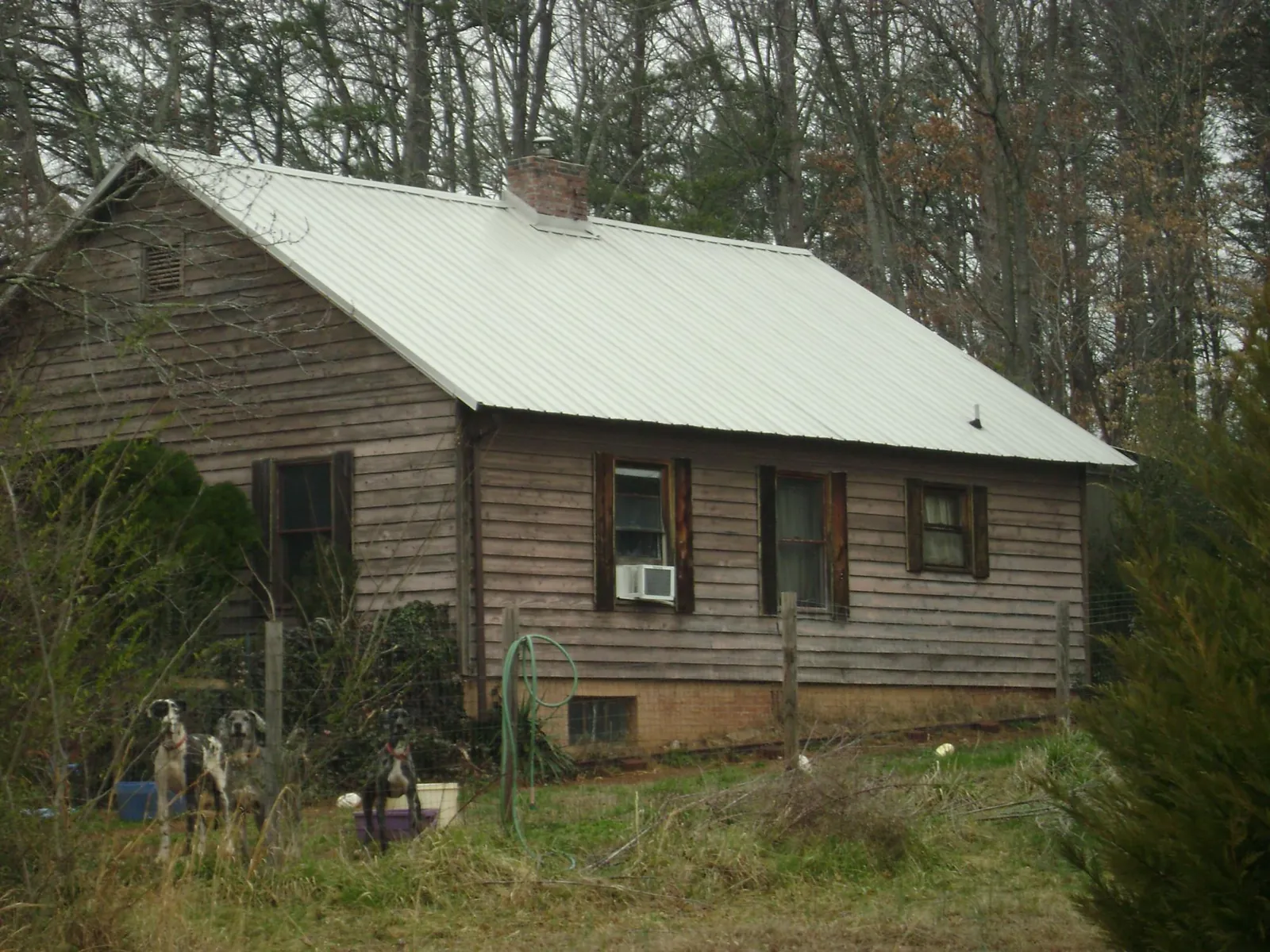 White metal roof on an old wood sided farmhouse, from a Asphalt Shingle Roof Repair job in Huntsville